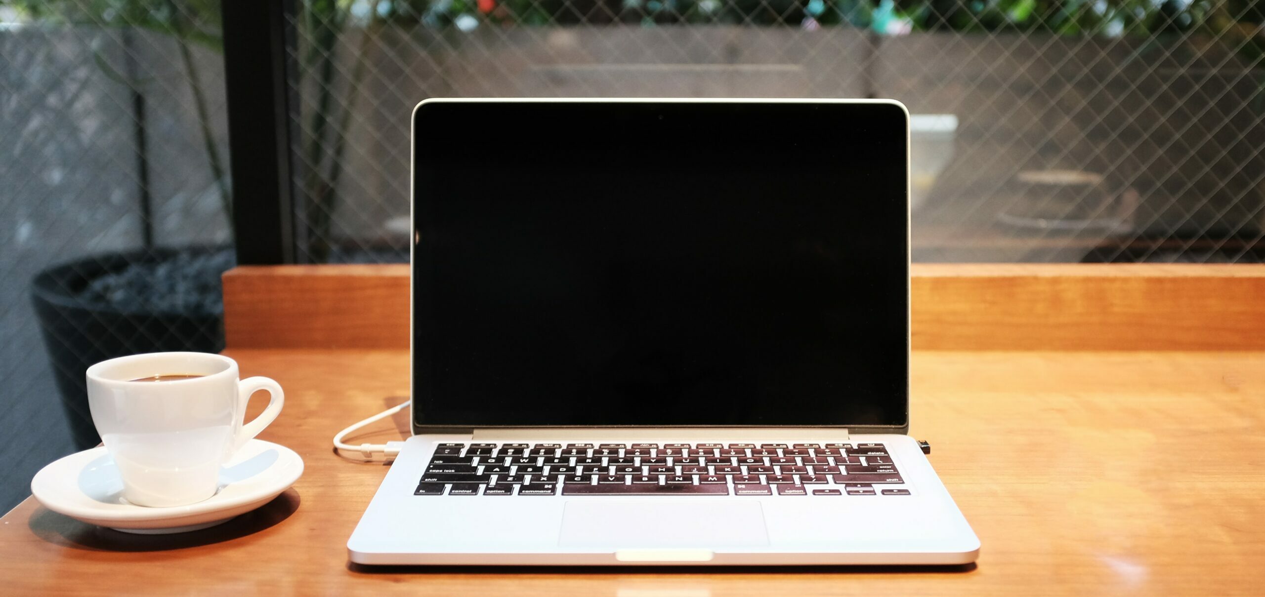 laptop computer beside coffee mug